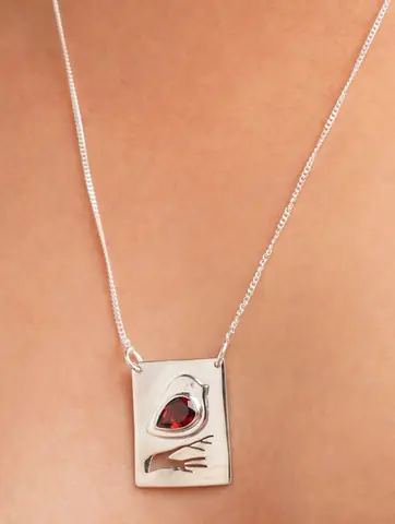 Close view of the square pendant with a dark red stone