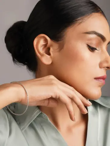 Model with a hand at the face wearing the bangle